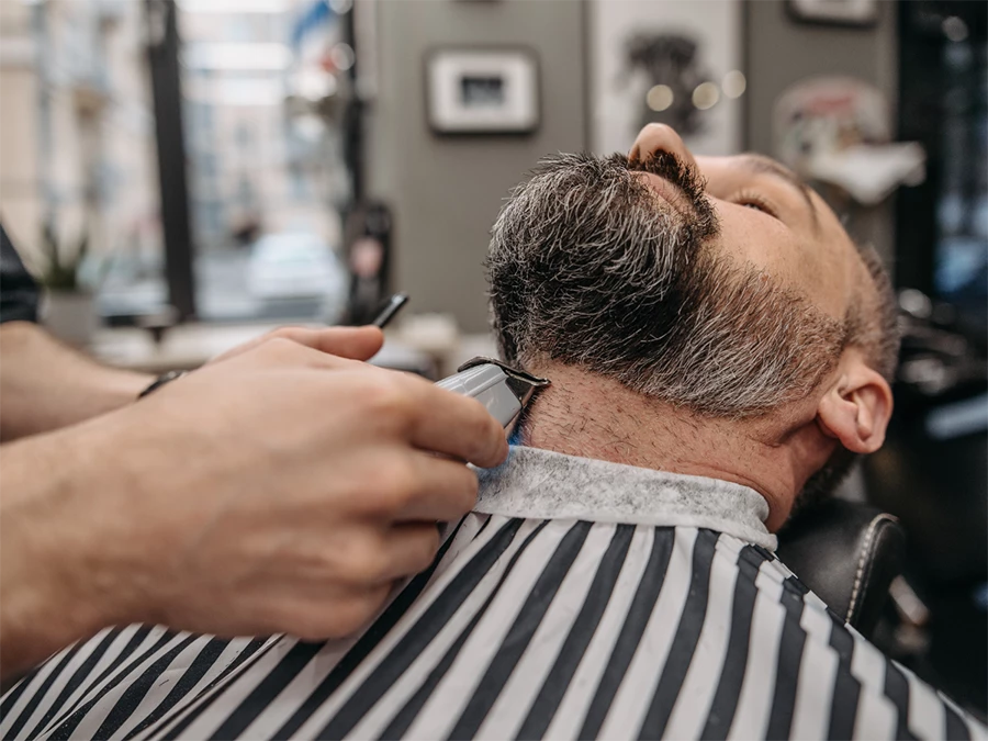 Expert beard trimmers in Meyerland area trimming a client's beard with precision at a professional barbershop.