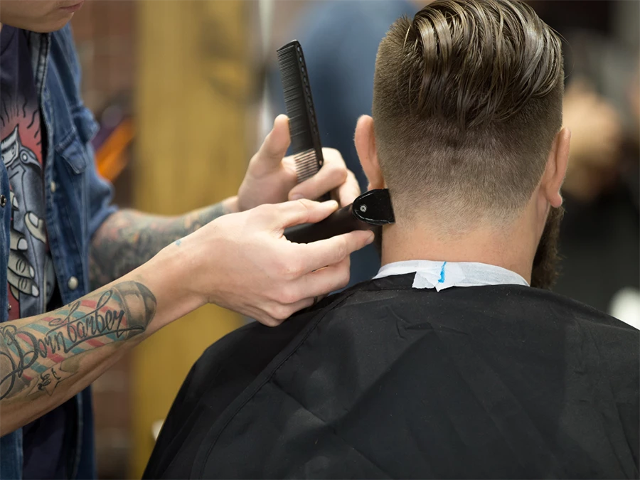 Barber trimming hair with clippers at Walk-in Barbershop in Bellaire