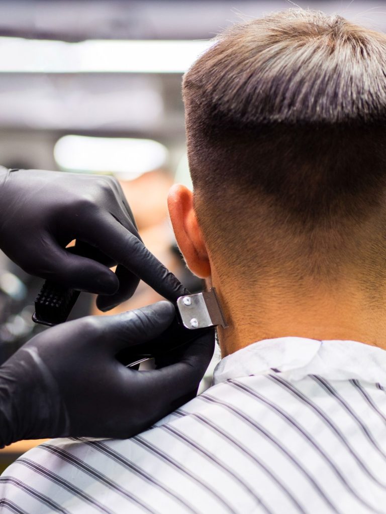 Close-up of a barber using clippers for a precise haircut in a professional salon setting.