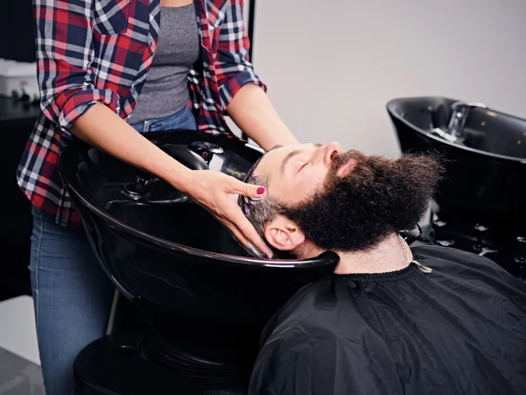 Professional hair wash at Hair Salons for Men Houston with a stylist massaging client's scalp