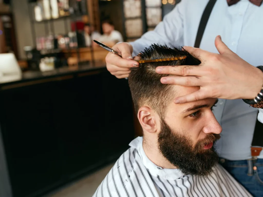 Close-up of a skilled barber using a comb on a client's hair, showcasing Barbers in Houston services