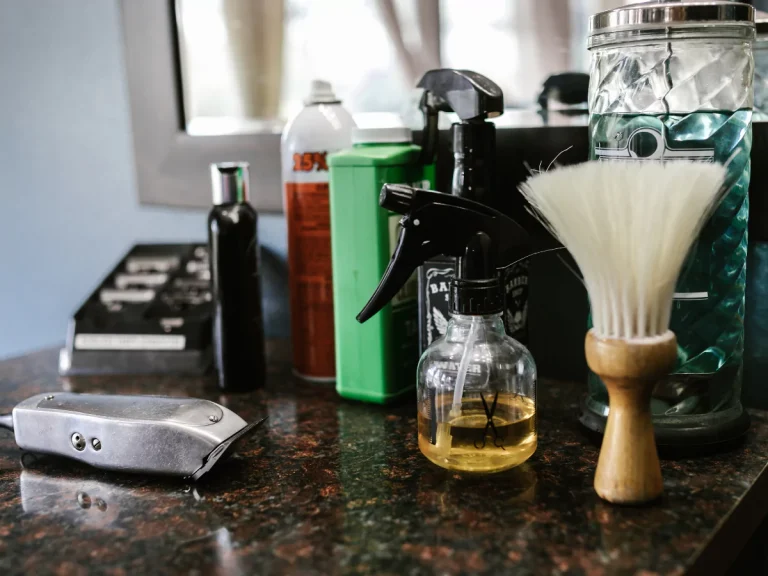 Barber Shop in Houston tools including a clipper, spray bottle, and shaving brush on a counter